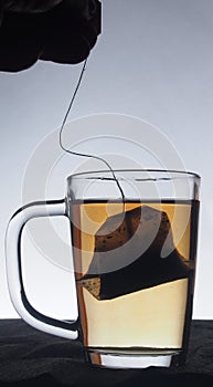 Glass transparent glass of the brewed tea. Tea is in a tea bag.