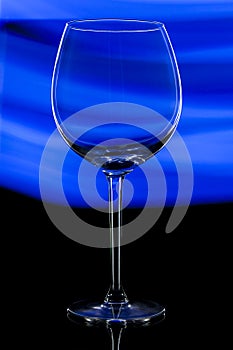 Glass transparent wine glass on abstract blue background