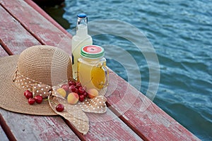Glass of tropical exotic multifruit juice and fruits at the pier. Tropical beach picnic.