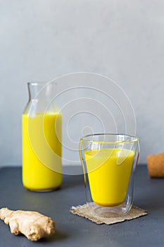 Glass tumbler with Golden milk. Delicious hot drink with turmeric to prevent diseases and support immune system.