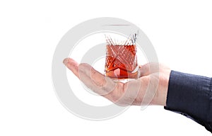 Glass Turkish armud with tea on a palm on a white background