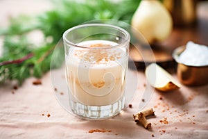 a glass of turnip juice with a sprinkle of chili flakes, surrounded by turnips