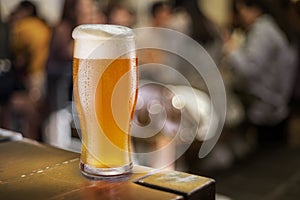 Glass of unfiltered beer stands on a table in a pub photo