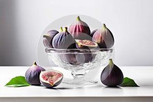 Glass vase with fresh ripe figs and halves on a white table. Ripe summer fruits