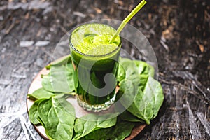 Glass with a vegetarian smoothie from green leaves of fresh spinach. Popular detox drink for healthy eating