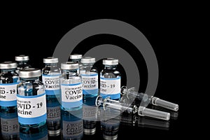 Glass vials labelled with COVID-19 text  on black background