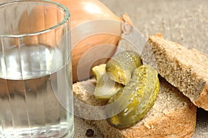 Glass of vodka, bread and pickled cucumber