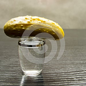 A glass of vodka fifty with pickled cucumber.