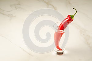 glass of vodka and red pepper/glass of vodka and red pepper on a