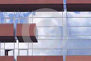 Glass wall with balcony and sky reflection background