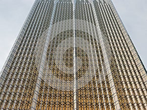 A glass wall of modern office building with a gold