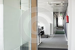 Glass wall and narrow passageway in office photo