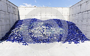 Glass waste in recycling facility. Blue bottles