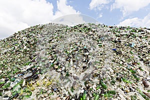 Glass waste in recycling facility. Pile of bottles.