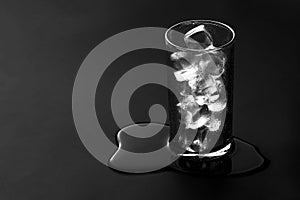 Glass of water on black matte surface
