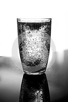 Glass of water with chia seeds floating around