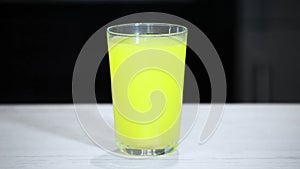 A glass of water with an effervescent vitamin tablet on a black background