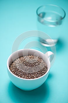 Glass of water and healthy chia seeds in a cup. Text space.