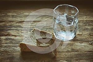 Glass of water and hunk black bread photo