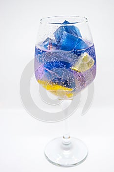 Glass of water with ice cubes isolated on white background,Butterfly pea or blue pea flower juice with lemon cool.