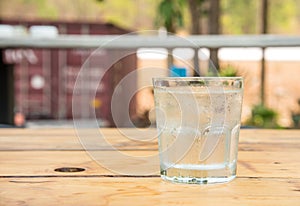 Glass water with ice,Drops water on glass,wooden table.