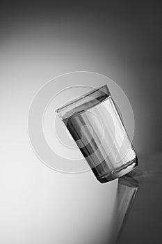 Glass of water. The inverted Cup. Glass of water on a dark background. Falling glass of milk.