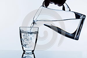 Glass with water and jug