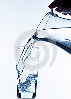 Glass with water and jug