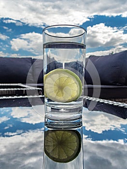 Glass of water with lemon on hot summer day