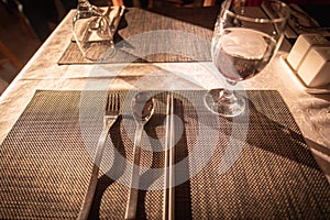 Glass of water on luxury table setting for dining. Selective focus. Warm tone