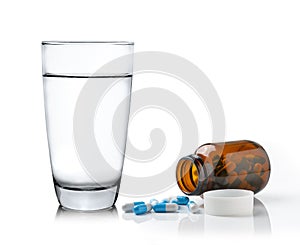 Glass of water Medicine bottle and pills isolated on white background