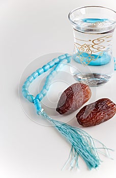 Glass of water, Organic dates Medjool and rosary.