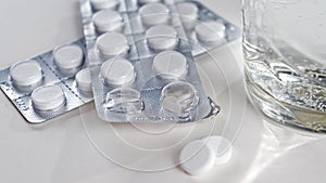 Glass of water and pills in blister pack