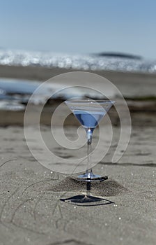 Glass with water on the sandy beach