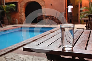 A glass of water sit on a wooden table