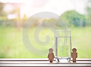 glass of water with wooden woman and man