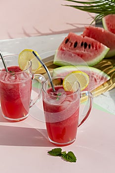 A glass of watermelon smoothie with ice, mint and lemon. Selective focus.