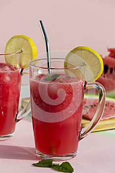 A glass of watermelon smoothie with ice, mint and lemon. Selective focus