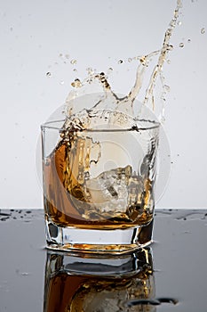 A glass of whiskey, drops, spray, splash of fluid, a stop time, after a hard working day, rest time, Scottish