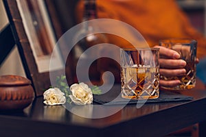 Glass of whiskey and flowers, still life, cinematic effect