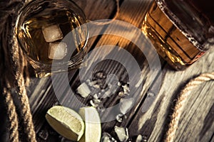 glass of whiskey, a glass of rum on a wooden bar counter