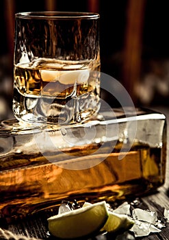 glass of whiskey, a glass of rum on a wooden bar counter