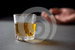 Glass of whiskey hand of a drunk man