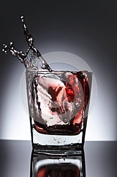 Glass of whiskey with ice on a black background