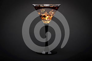 Glass of whiskey with ice or brandy isolated on a black background. Whiskey with ice in the glass on a black background.