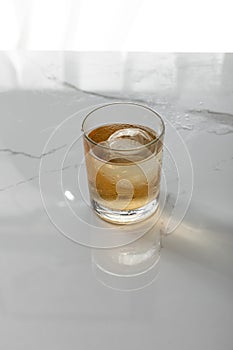 Glass of whiskey with ice cube