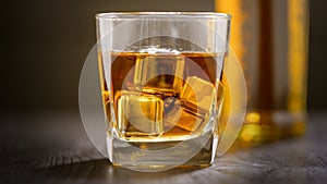 Glass of Whiskey with ice cube on wooden table