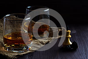 Glass of whiskey with ice on a wooden background.