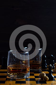 Glass of whiskey with ice on a wooden background.