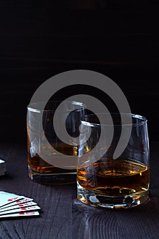 Glass of whiskey with ice on a wooden background.